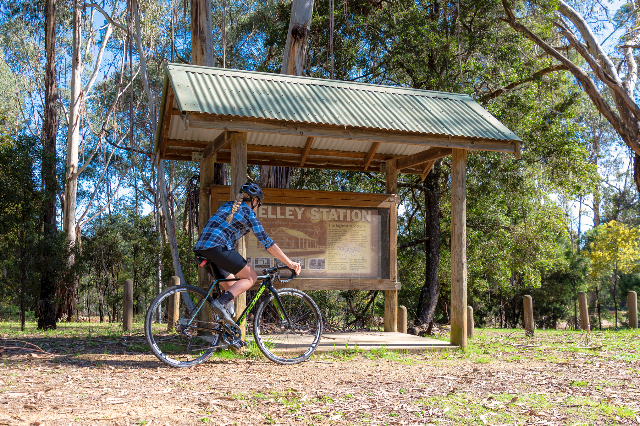 A cyclist at the Shelley Station sign on the High Country Rail Trail