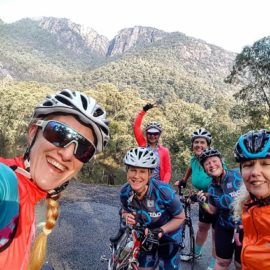 A group of women cyclists pose for a photo while riding up Mount Buffalo